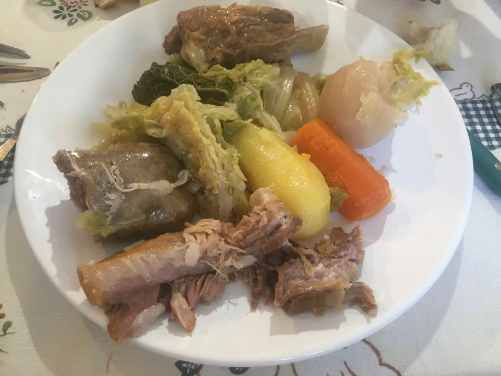 Potée auvergnate : viandes de porc, chou et légumes servis dans un grand plat