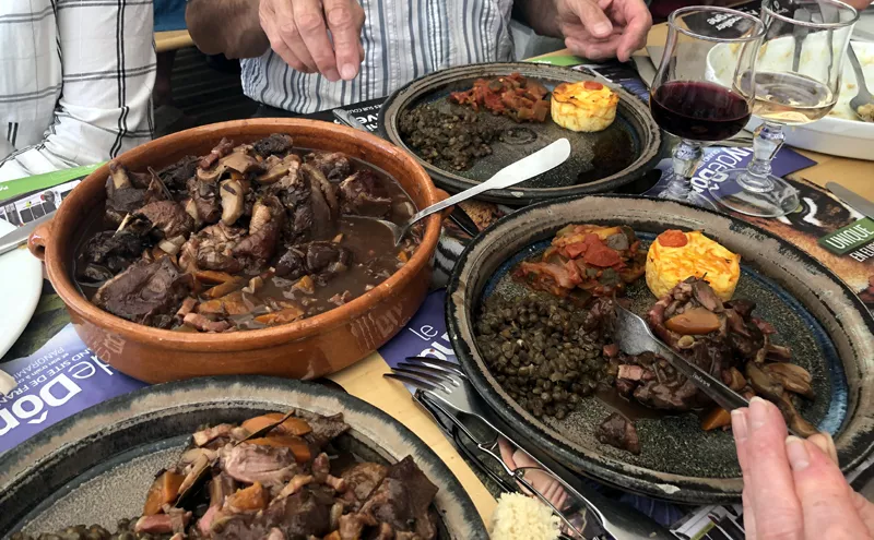 Coq au vin d'Auvergne servi avec ses croûtons de pain de mie